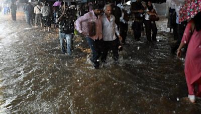 Mumbai rains: Commuters struggle through knee-deep water as heavy rains lash parts of Mumbai and adjoining areas