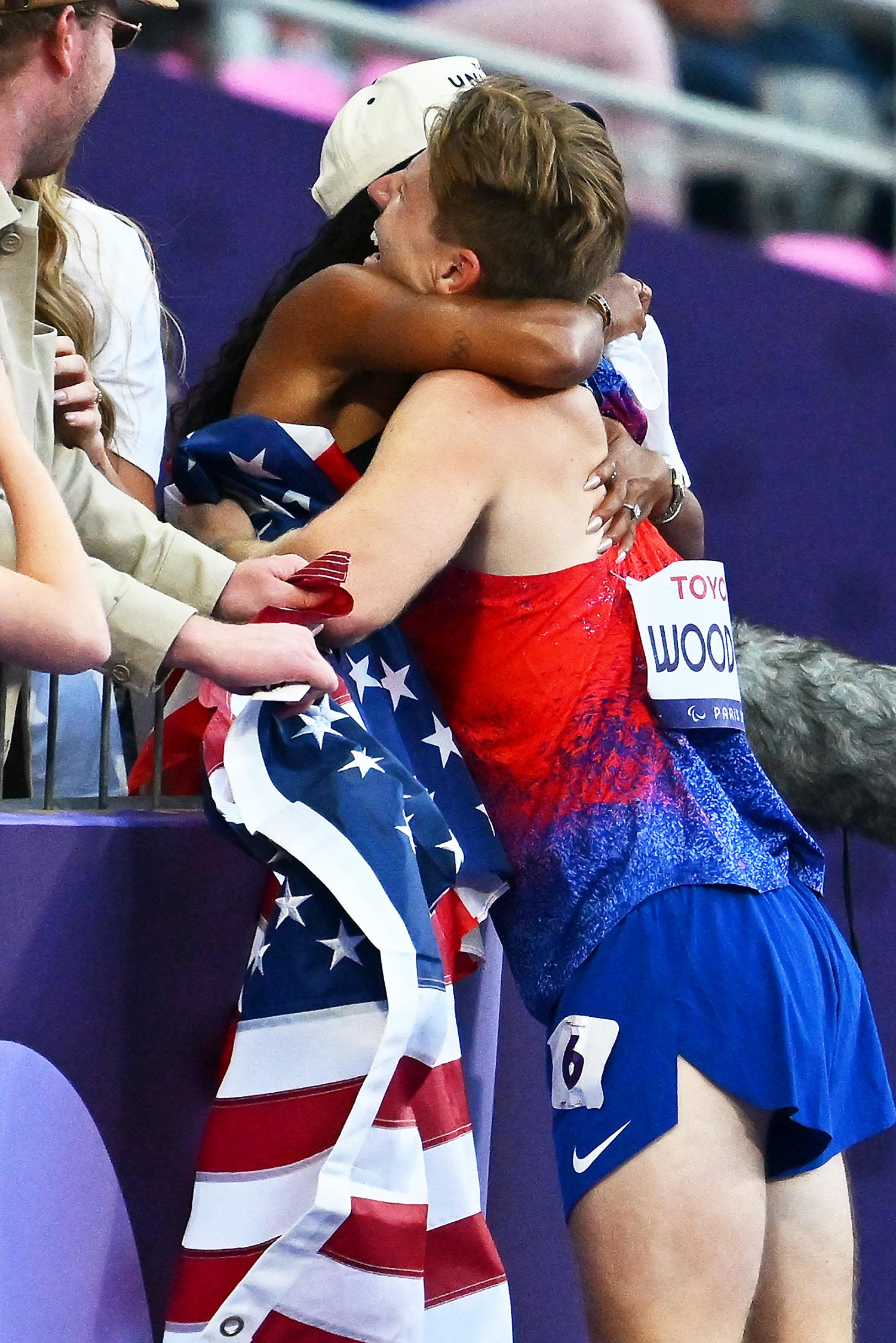 Hunter Woodhall and wife Tara embrace after he wins his first gold medal at the Paralympics