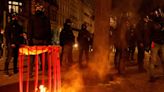 Protesters set rubbish on fire as French govt barely survives no-confidence vote