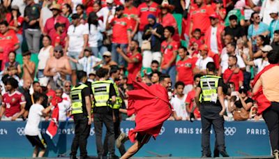 Morocco fans rush field during Olympic soccer opener vs Argentina. Game suspended, goal disallowed