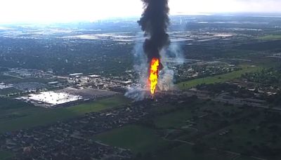 A pipeline explosion sends a towering pillar of flame over Houston's suburbs