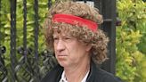 Tennis legend John McEnroe looks unrecognisable as he dons huge curly wig