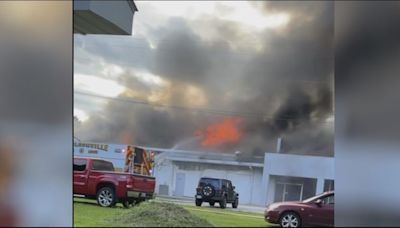 Multiple fire departments work to put out flames at car dealership