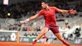 Novak Djokovic of Serbia stretches to play a backhand against Lorenzo Musetti of Italy in the Men's Singles third round match during Day Seven of the 2024 French Open at Roland...