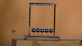 Watch a bullet blasting into a Newton's cradle in extreme slow motion