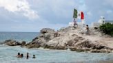 Gunmen on jet skis open fire at rival drug dealer at a beach in Cancun, killing a 12-year-old boy