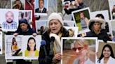 Families of victims of the March 10, 2019, crash of a Boeing 737 MAX airplane in Ethiopia hold up photos of the dead during a protest in Arlington, Virginia