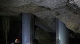 Environmental activist Roberto Rojo stands next to metal columns inside a cave supporting Mexico's controversial Maya Train