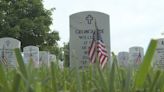 Hundreds of people place flags on graves at Camp Nelson National Cemetery