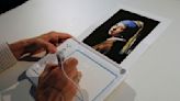 Activist glues his head to 'Girl with a Pearl Earring' painting in The Hague