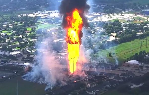 A pipeline explosion is shooting a towering pillar of flame over a Houston suburb