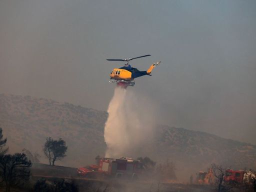 Bomberos griegos combaten un nuevo incendio forestal cerca de Atenas en medio de fuertes vientos