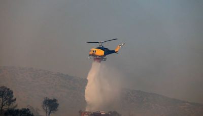 Bomberos griegos combaten un nuevo incendio forestal cerca de Atenas en medio de fuertes vientos