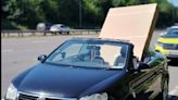 Wild pictures show man driving convertible with huge 60-inch telly hanging out along M60