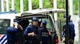 Belgian police stand guard during searches conducted at the European Parliament building as part of a probe into suspected Russian interference