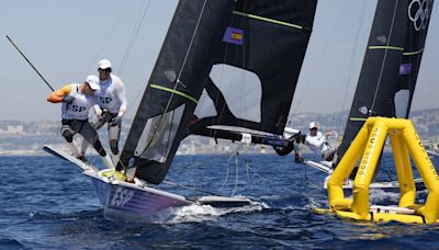 Olympic sailing ready to start with fast windsurfing, bird-like skiffs under light winds, hot sun