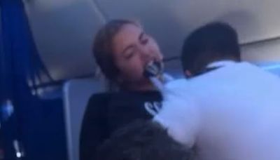 Shocking moment airline passenger bites flight attendant in mid-air meltdown