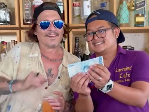 Johnny Depp Happily Samples a Drink Behind the Bar While Visiting a Restaurant in the Bahamas