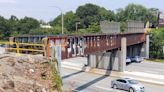 Abandoned brown and orange railroad bridge over I-95 coming down