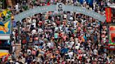 Alberta's premier, Opposition leader saddle up to flip pancakes at Calgary Stampede