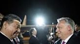 Chinese President Xi Jinping (L) is greeted by Hungarian Prime Minister Viktor Orban (R) at the airport