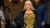 Christina Aguilera pairs her puffer jacket with a corset and thigh-high boots