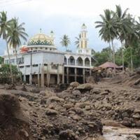 Hours of heavy rain caused large volcanic rocks to roll down one of Indonesia's most active volcanos into two of the worst-hit districts on Sumatra island