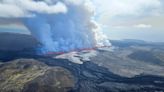 An Iceland volcano spews red streams of lava toward an evacuated town