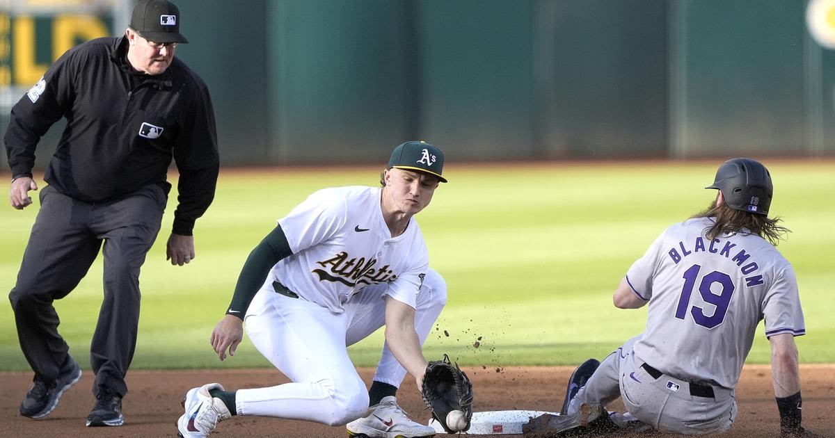 The Colorado Rockies' Charlie Blackmon steals second base, sliding in ahead of the throw to Zack Gelof of the Oakland Athletics in the first inning at the Oakland Coliseum...