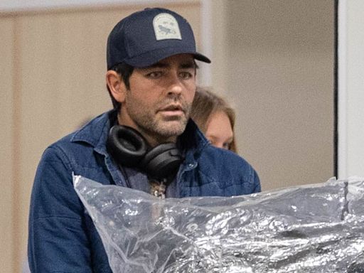 Adrian Grenier pushes mountains of luggage as he arrives in Byron Bay