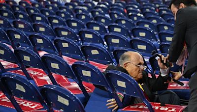 Rudy Giuliani takes a fall and tumbles into chairs while walking RNC floor