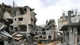 A Palestinian pulls a cart past destroyed buildings in Khan Yunis in southern Gaza