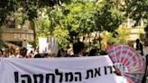 Demonstrators hold up a banner reading 'Stop the war' during the annual SlutWalk in central Jerusalem