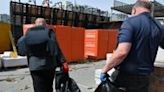 Utility workers carry a bodybag as they evacuate the remains of a victim who was killed in a hardware supermarket in Kharkiv destroyed by a Russian strike, on May 26, 2024, amid the Russian invasion of Ukraine.