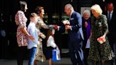 King and Queen exchange flowers and presents with children as Charles resumes public duties