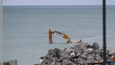 Monster 90-ton digger is swamped by incoming tide & knocked out of action