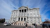 Anti-migrant signs attached to parking posts outside Colorado State Capitol