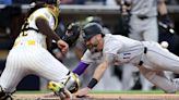 ...Diego Padres is unable to place the tag on Jake Cave as he scores on a triple hit by Elehuris Montero of the Colorado Rockies during the fourth inning at Petco Park on Monday, May...