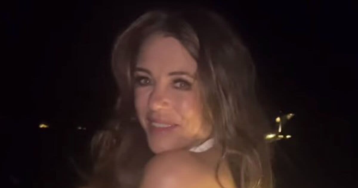 Braless Liz Hurley, 58, almost flashes fans as she dances in risqué white dress