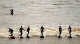 Surfers ride huge Severn Bore tidal wave in Gloucestershire