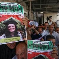 Palestinians hold pictures of Aysenur Ezgi Eygi during a memorial procession for the slain activist