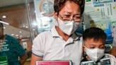 Mary Ann Domingo and her younger son hold portraits of her husband and son after four policemen were found guilty of killing them during an anti-drug raid