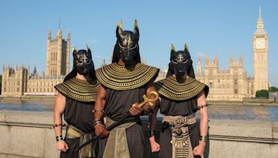 Moment drivers stop as trio dressed as Egyptian Gods stroll along busy street