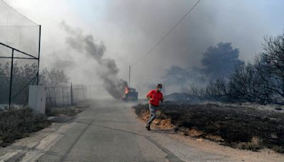 Drop in winds offers hope as Greek firefighters battle huge wildfire scorching the fringes of Athens