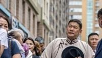 Mongolia's Prime Minister Luvsannamsrain Oyun-Erdene (3rd R) waits to cast his vote in the Mongolian parliamentary elections outside a polling station in Ulaanbaatar