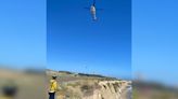 Stranded kite surfer rescued after writing 'HELP' out of rocks in the sand