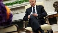 US President Joe Biden looks at note cards as he meets with Romanian President Klaus Iohannis in the Oval Office of the White House in Washington...