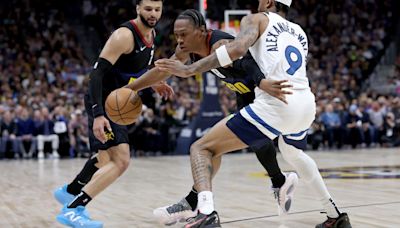 Peyton Watson of the Denver Nuggets attempts to drive past Nickeil Alexander-Walker of the Minnesota Timberwolves during the second quarter in Game 2 of...