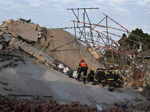 Rescuers bring out survivors from the rubble a day after a deadly building collapse in South Africa