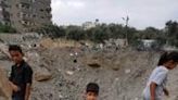 Palestinian children near the crater left by an Israeli strike in Nuseirat in the central Gaza Strip on June 3, 2024